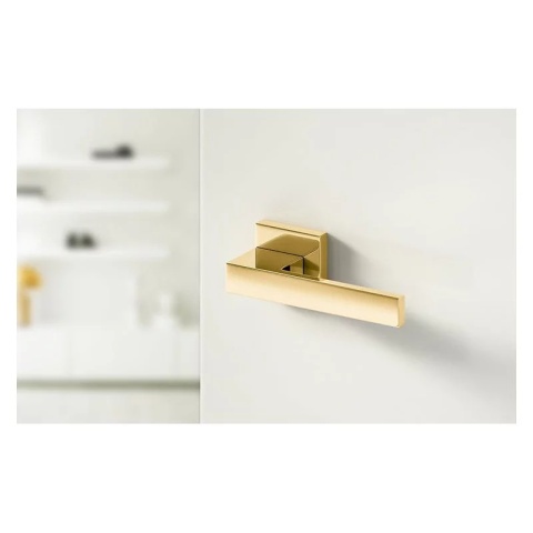 Klamka Grand mosiądz błyszczący PVD na rozecie kwadratowej Corona